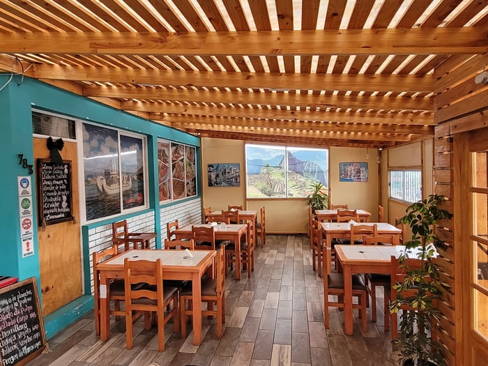 Interior real de Brasas Limeñas, con su mural y la carta en la pizarra